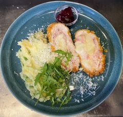 Corn flakes bundában sült csirkemell, baconnel, mozzarellával töltve, rukkolás burgonyapüré, áfonya lekvárral